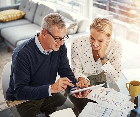 Couple looking at finances on a smart tablet